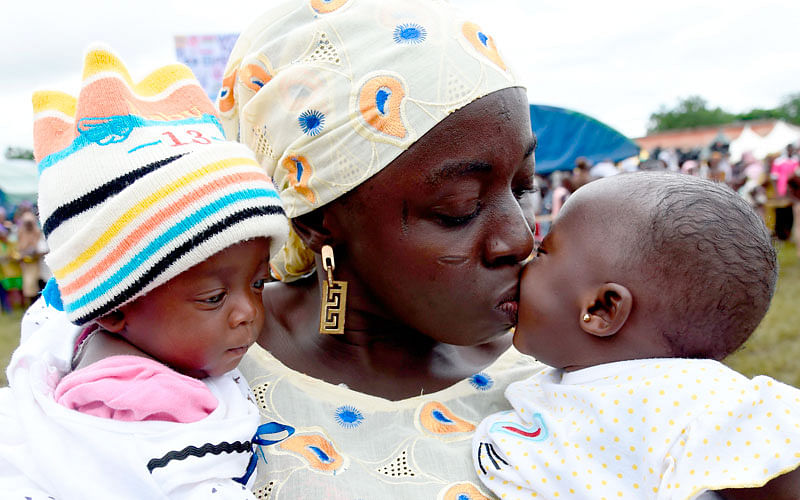 A mother kisses one of twins during the Igbo-Ora World Twins festival to celebrate the uniqueness in multiple births at Igbo-Ora Town in Oyo State, southwest Nigeria, on 12 October 2019. Photo: AFP