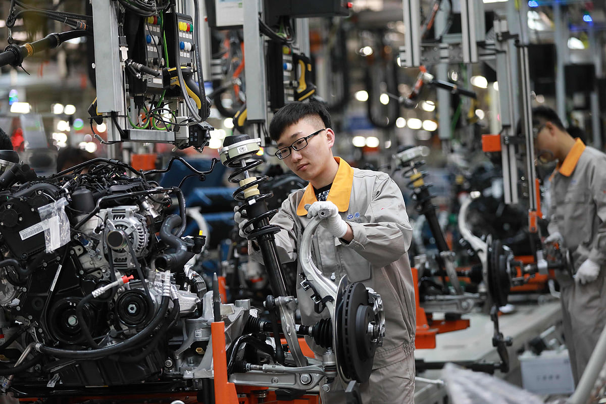 In this file photo taken on 1 November 2017 shows a Chinese employee working on a production line of automobiles at a factory in Changchun in China`s northeastern Jilin province. Photo: AFP