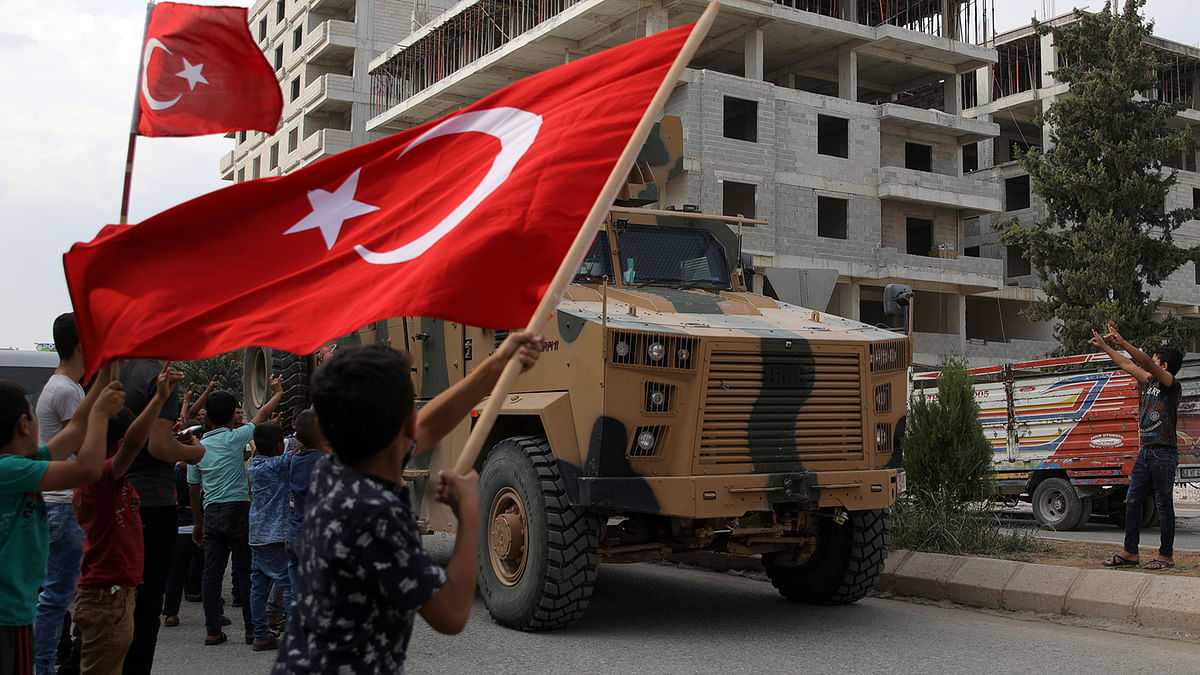 People cheer as Turkish military vehicles drive on a street in the Turkish border town of Akcakale in Sanliurfa province, Turkey, 16 October, 2019. Photo: Reuters