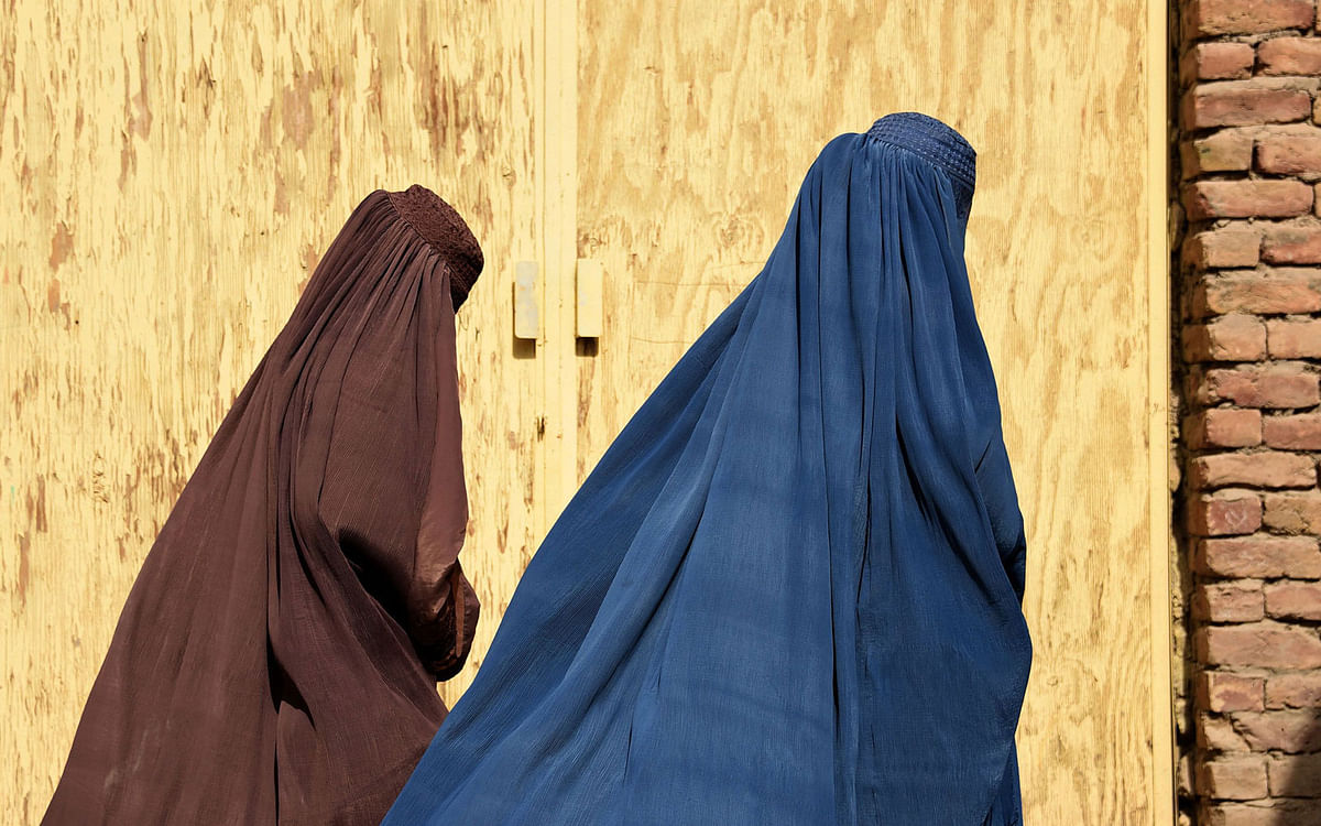 Afghan women wearing burqas from a polio immunisation team walk together during a vaccination campaign in Kandahar on 15 October 2019. Photo: AFP