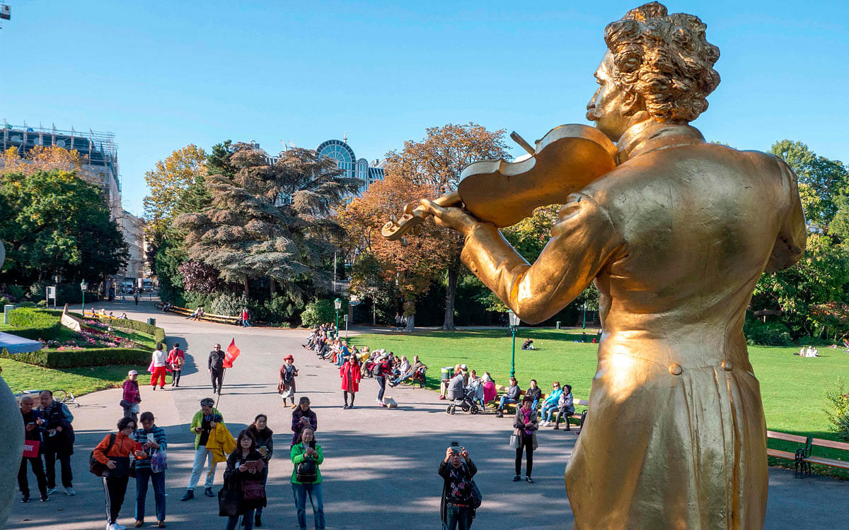 A tourist takes a pictures of a statue of the Austrian composer Johann Strauss at Stadt park in Vienna, Austria on 16 October 2019. Photo: AFP