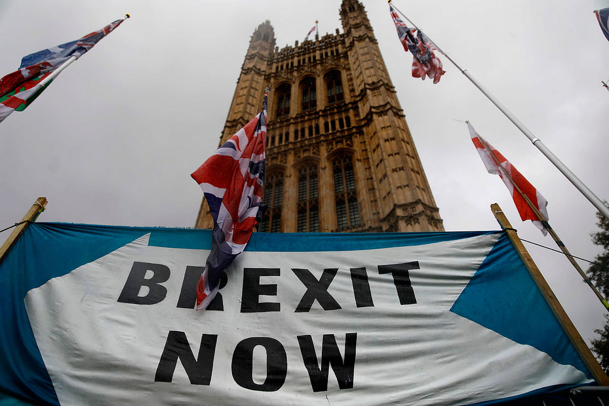 Pro-Brexiteers hold a banner near the Houses of Parliament in Westminster, central London on 17 October 2019. Britain`s prime minister Boris Johnson and the European Union on Thursday reached a provisional agreement that might just see Britain leave the European Union by the 31 October deadline. Photo: AFP
