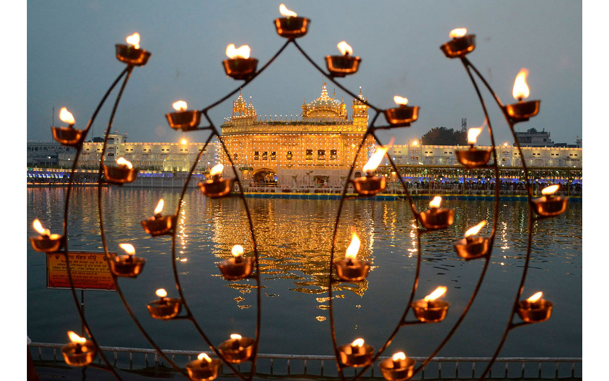 Sikh devotees pay respect on the occasion of the birth anniversary of the fourth Sikh Guru Ramdas at the illuminated Golden Temple in Amritsar on 15 October 2019. Photo: AFP