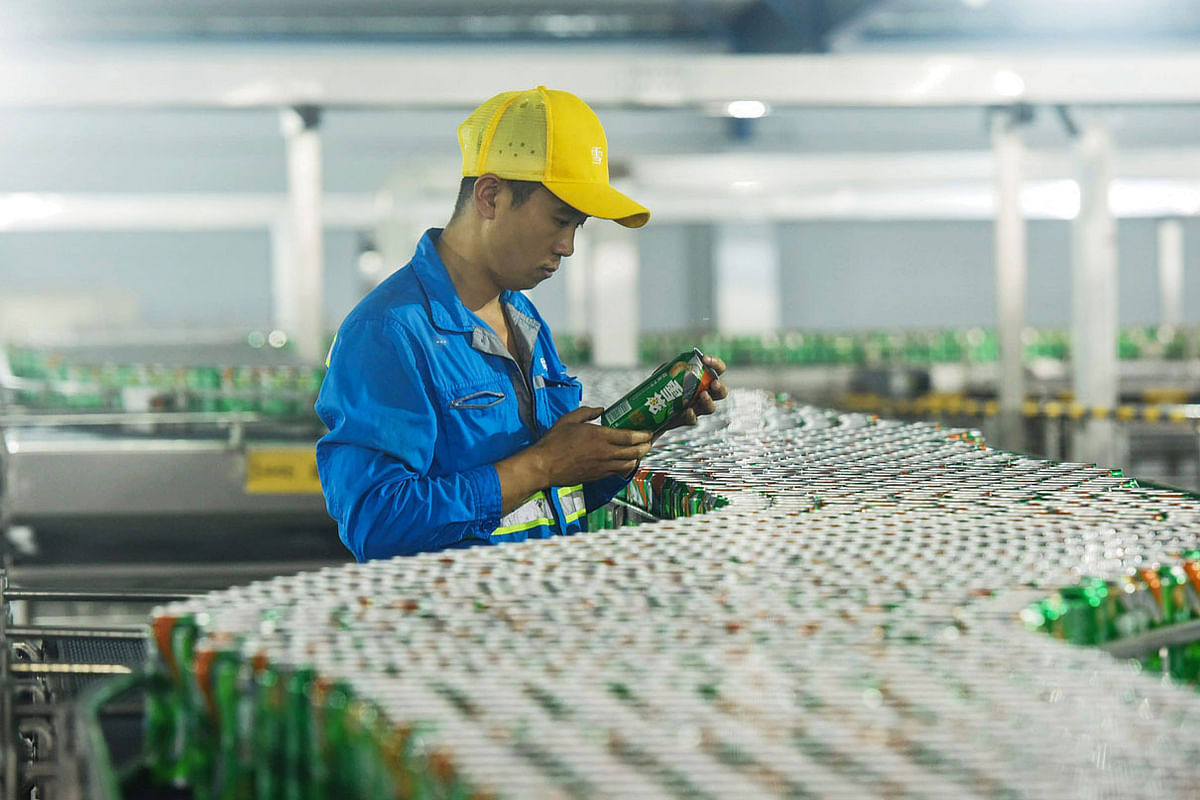 A worker checks a can of beer at a beer factory in Hangzhou in China`s eastern Zhejiang province on 18 October. Photo: AFP