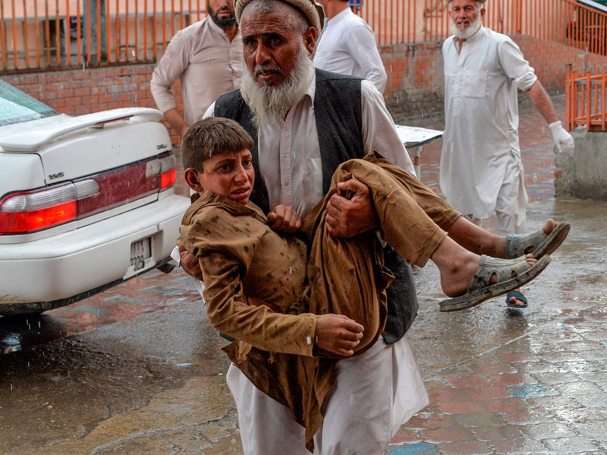 A volunteer carries an injured youth to hospital, following a bomb blast in Haska Mina district of Nangarhar Province on 18 October, 2019. Photo: AFP