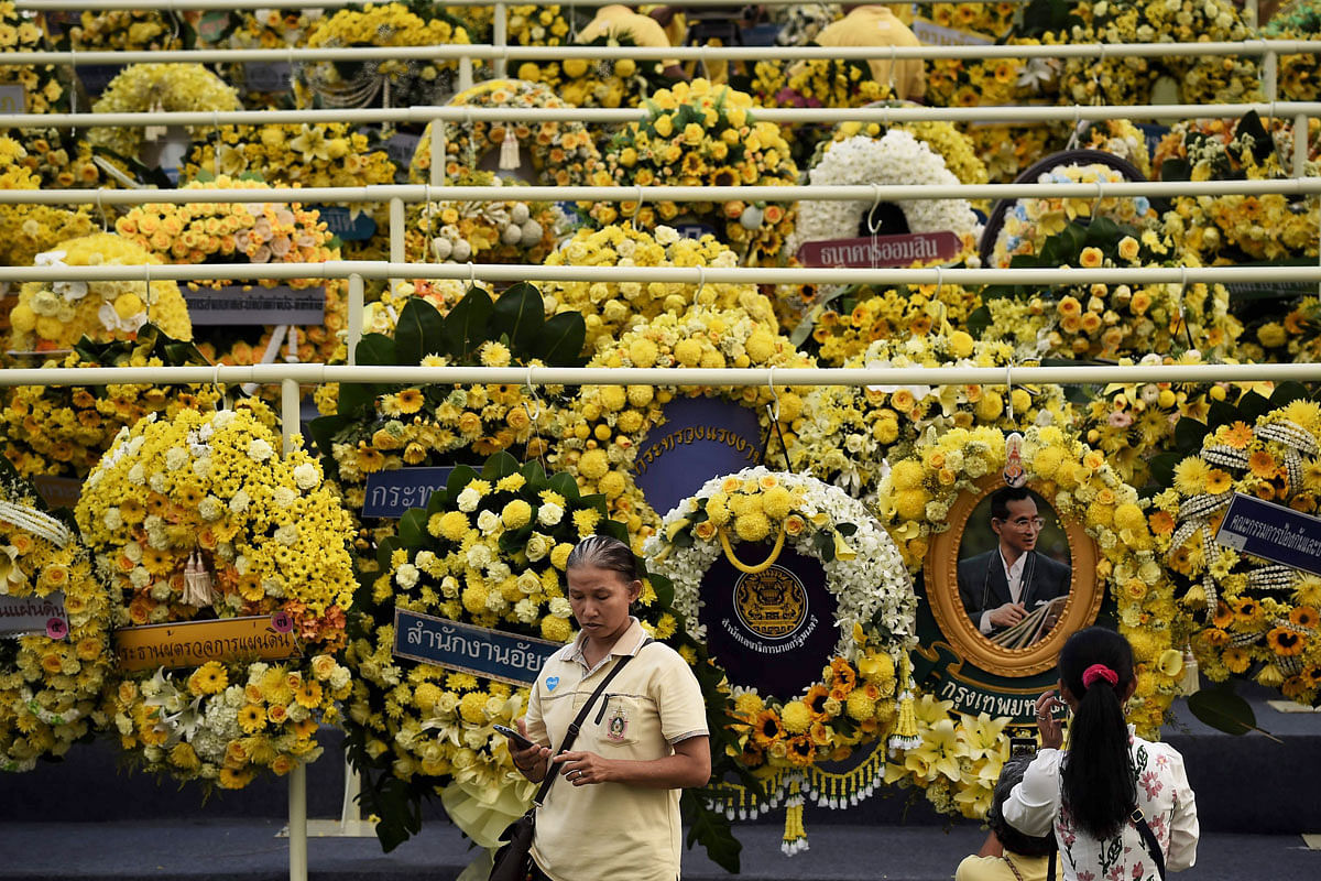 eople take photographs with mourning wreaths during a ceremony to commemorate the 3rd anniversary of the death of the late Thai King Bhumibol Adulyadej, in front of the Grand Palace in Bangkok on 13 October 2019. Photo: AFP