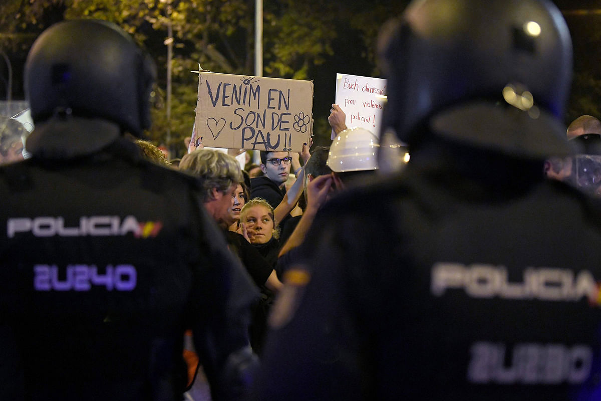 A protester holds up a sign reading in Catalan `We come in peace` in front of police during a demonstration called by the Catalan pro-independence left youth group `Arran` on 19 October 2019 in Barcelona, a day after nearly 200 people were hurt in another night of violent clashes in Catalonia. Photo: AFP