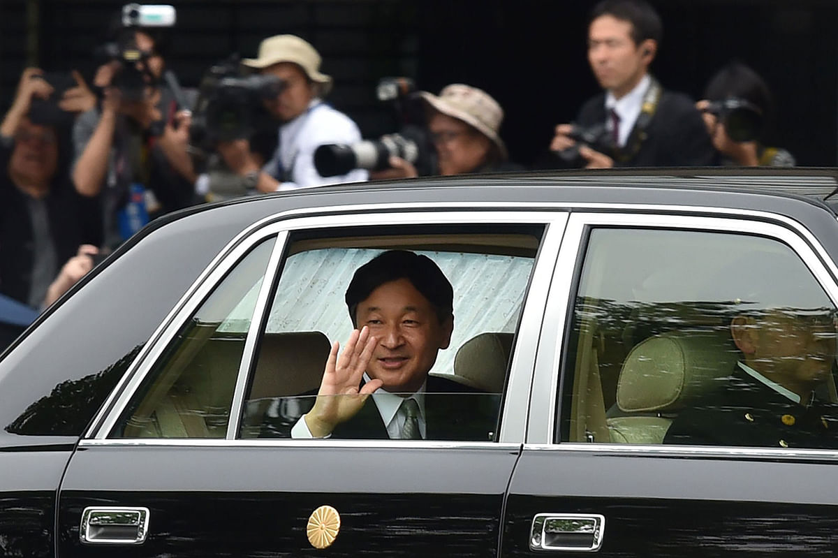 In this file photo taken on 1 May 2019, Japan`s new Emperor Naruhito (C) waves to well-wishers as he arrives back at the Imperial Palace in Tokyo. Photo: AFP