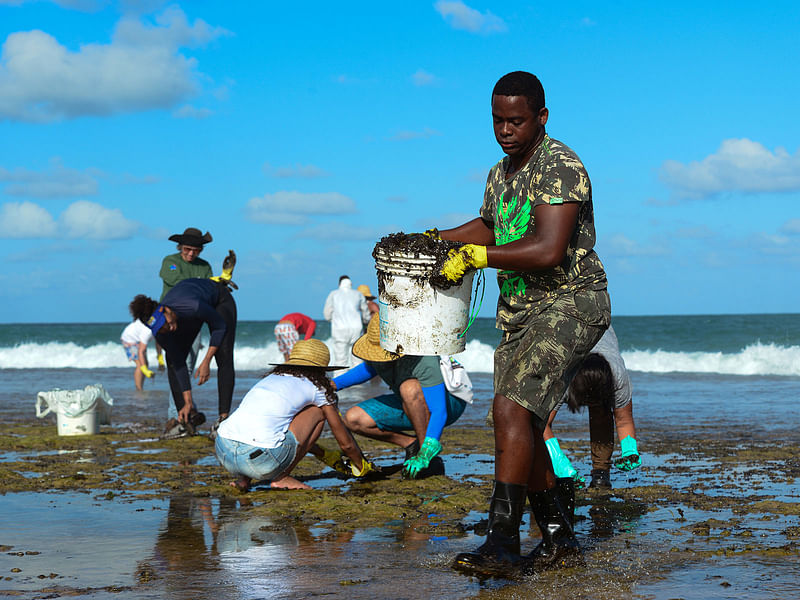 A man works to remove an oil spill on Muro Alto beach in Tamandare, Pernambuco state, Brazil on 19 October 2019. Photo: Reuters