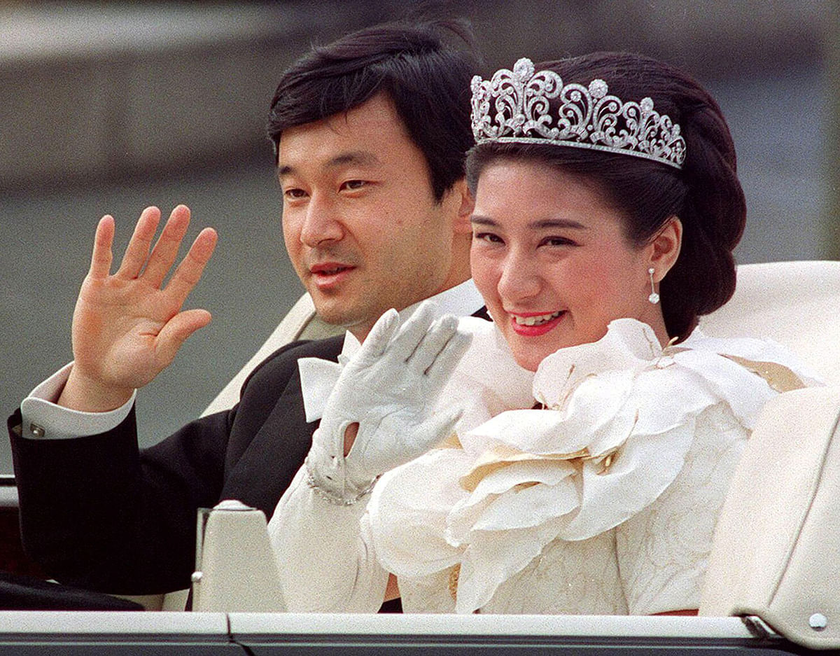 In this file photo dated 9 June 1993, Japanese then-Crown Prince Naruhito (L) and then-Crown Princess Masako (R) wave to people during a parade after their wedding ceremony in Tokyo. Photo: AFP