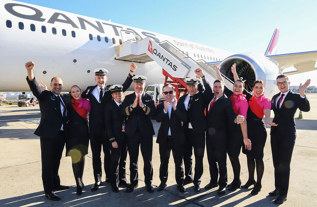 In this handout photo from Qantas shows Qantas Group CEO Alan Joyce (C) and crew celebrating in front of a Qantas Boeing 787 Dreamliner plane after arriving at Sydney international airport after completing a non-stop test flight from New York to Sydney on 20 October 2019. Photo: AFP