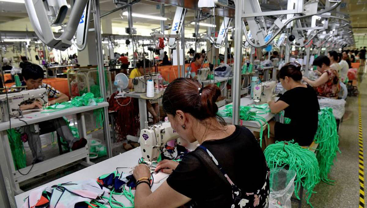 Workers sew swimsuits at a factory of the Qicaihu Garments & Weaving Co, in Jinjiang, southeast China`s Fujian Province on 14 August. Photo: Xinhua/ UNB