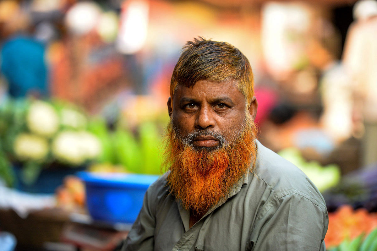 In this photo taken on 24 December 2018, vegetable vendor and henna enthusiast Munir Hossain with a henna-dyed beard and hair poses for a photo in Dhaka. Photo: AFP