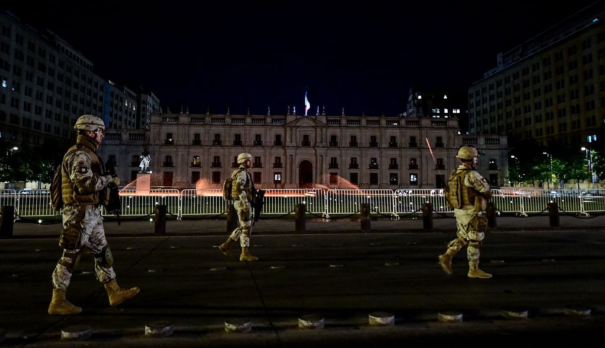 Chilean soldiers guard the surroundings of the Government Palace La Moneda in Santiago, Chile on 21 October 2019. Chile ordered an overnight curfew for the third day in a row on Monday as violent demonstrations and looting that left 11 people dead continued for a fourth straight day. The demonstrations against the metro ticket prices exploded into violence on October 18, unleashing widening protests over living costs and social inequality. Photo: AFP