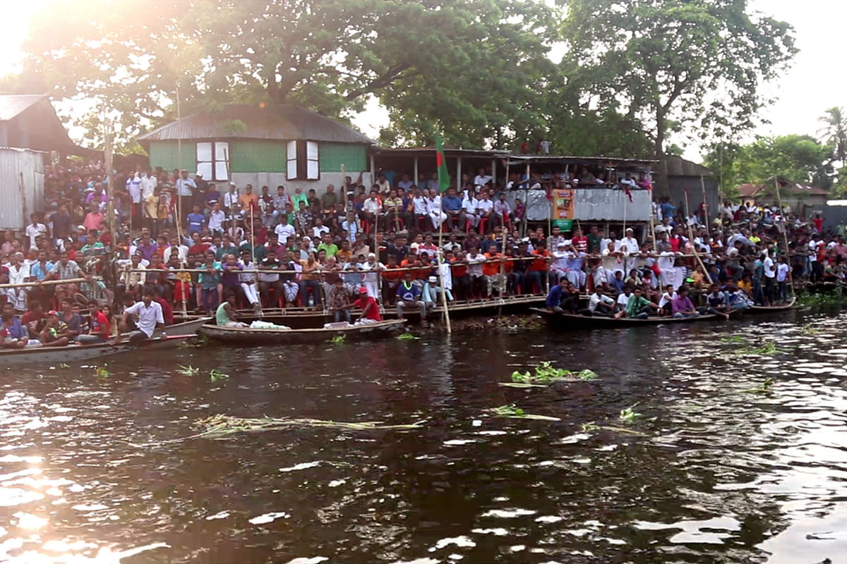 People watch the boat race at river Chiknai.