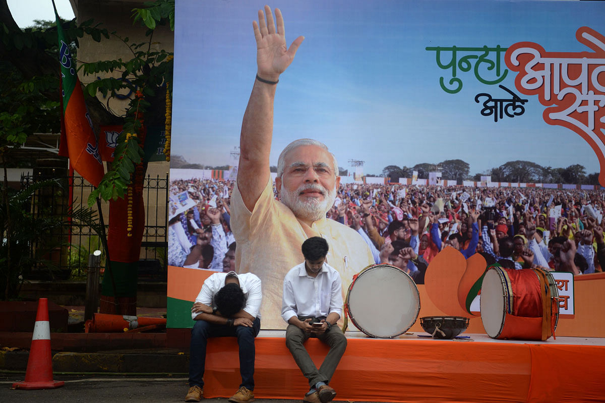 Supporters of India`s Prime Minister Narendra Modi and his ruling Bharatiya Janata Party (BJP) sit on a stage ahead of the announcement of the Maharashtra state election results outside the BJP headquarters in Mumbai on 24 October 2019. Photo: AFP
