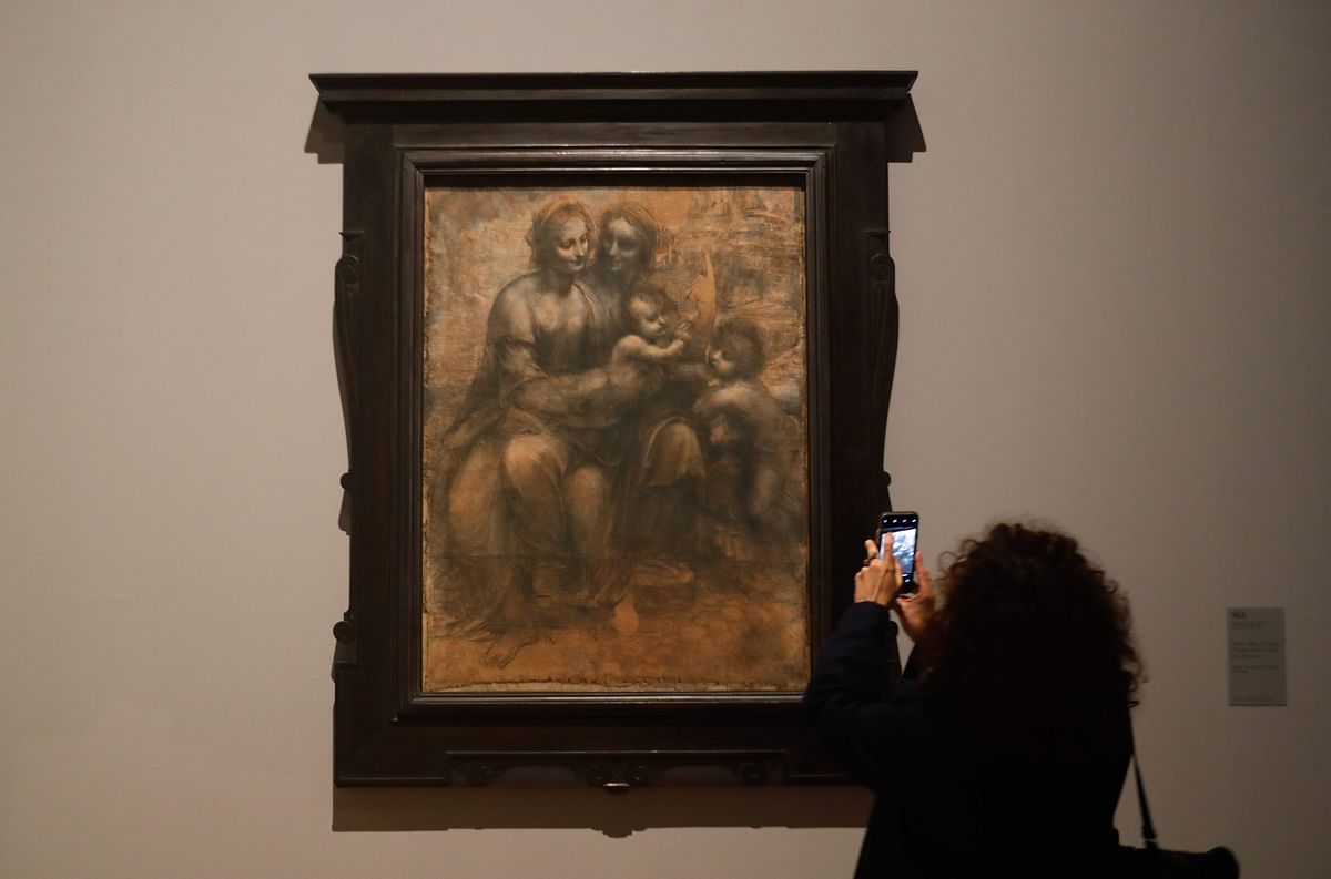 A woman looks at a drawing by Leonardo da Vinci`s ` The Virgin, the Child Jesus with Saint Anne and Saint John the Baptis `, during the opening of the exhibition ` Leonardo da Vinci `, on 22 October 2019 at the Louvre museum in Paris. Photo: AFP