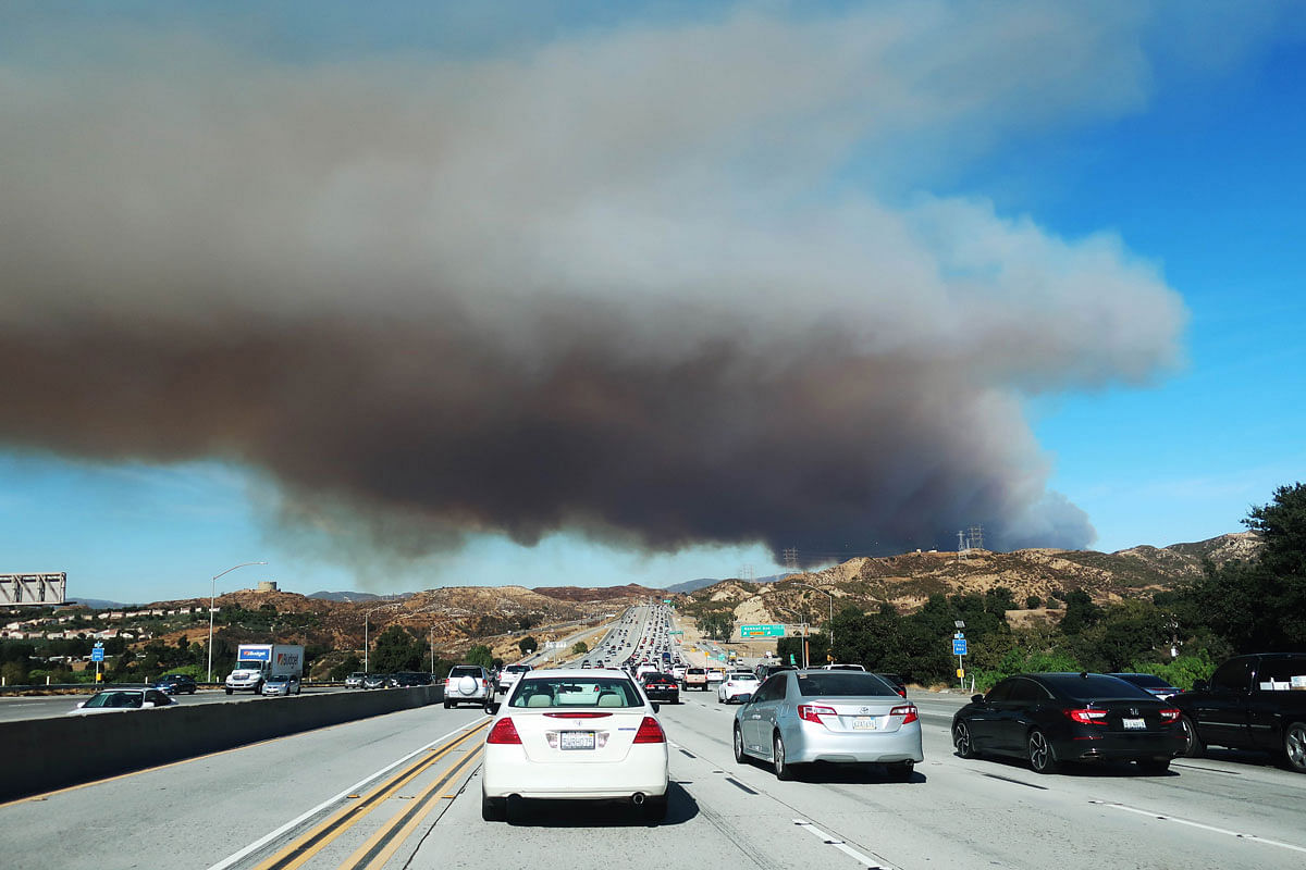 People drive on a freeway as the Tick Fire burns in nearby Canyon Country on 24 October 2019 in Santa Clarita, California. The fire has burned over 3,700 acres thus far and destroyed at least seven structures. Photo: AFP