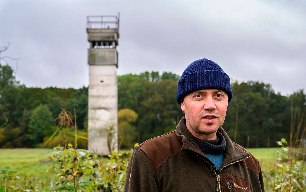 Former border guard Olaf Olejnik, who now works for the nature group BUND, poses next to an old east German watch tower in the so called `Green Belt` on the former border between east and west Germany near Salzwedel, northern Germany, on 8 October 2019. Once a zone blocked off with barbed wire, littered with landmines and manned by soldiers with shoot-to-kill orders, today much of the 1,393-km (865-mile) border dividing the former East from the West is a thriving nature paradise. Photo: AFP