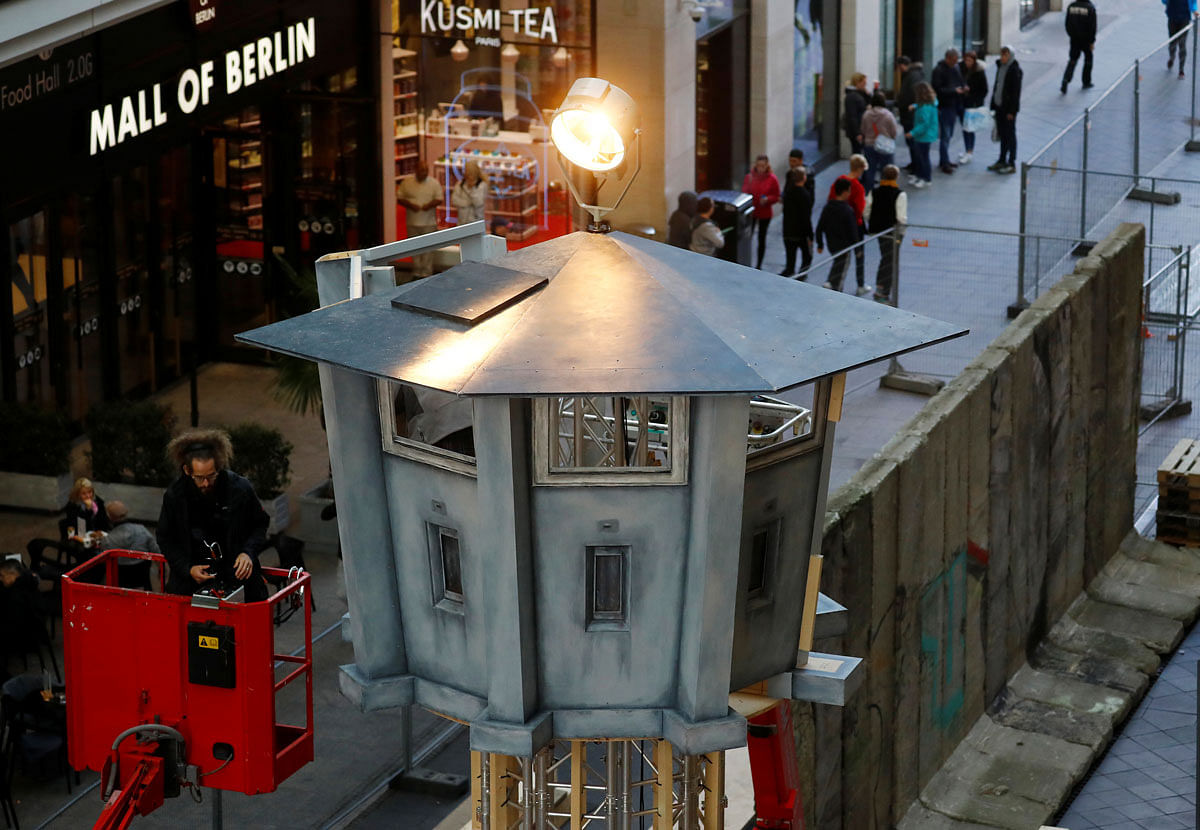 Workers set up model of a watch tower of the former GDR border at a shopping mall in Berlin. Photo: Reuters