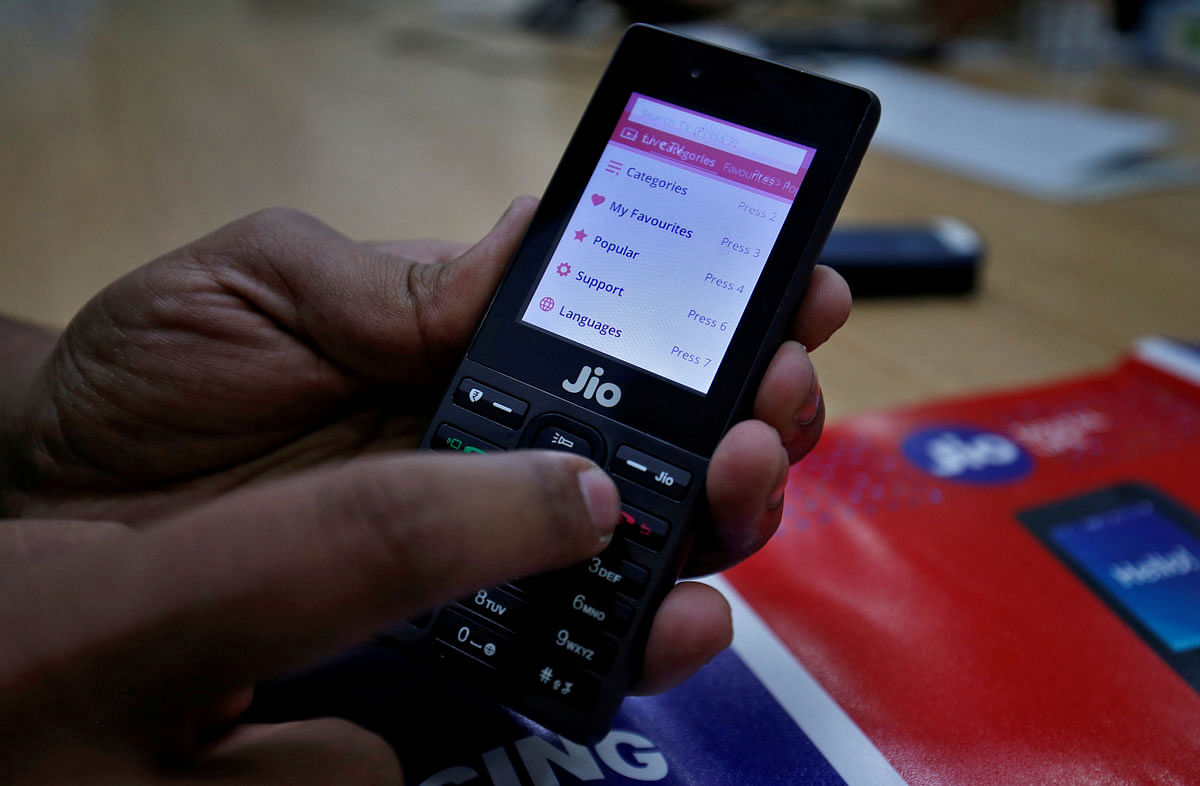 A sales person displays features of JioPhone as he poses for a photograph at a store of Reliance Industries` Jio telecoms unit, on the outskirts of Ahmedabad, India, on 26 September 2017. Reuters File Photo