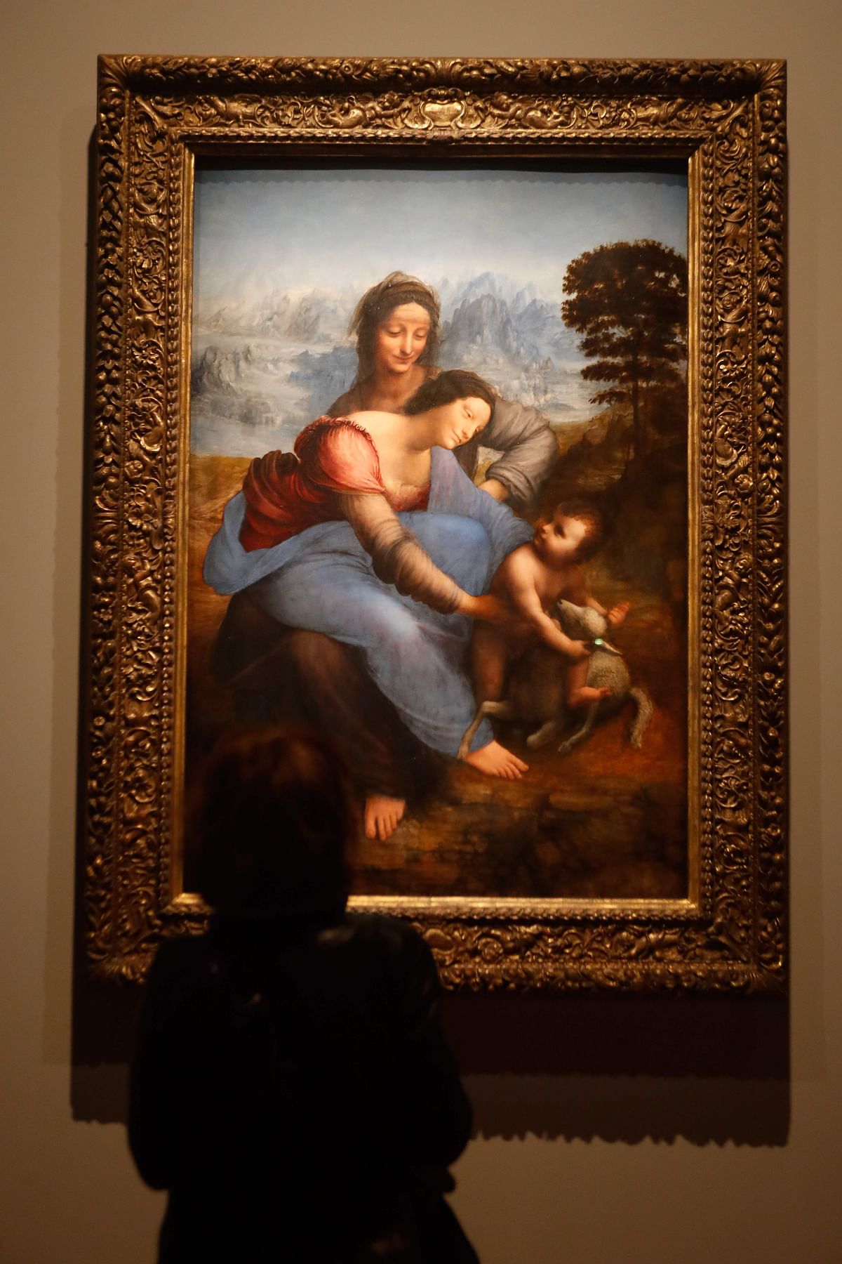 A woman looks at an oil painting by Leonardo da Vinci`s ` The Virgin and Child with Saint Anne `, during the opening of the exhibition ` Leonardo da Vinci `, on 22 October 2019 at the Louvre museum in Paris. Photo: AFP