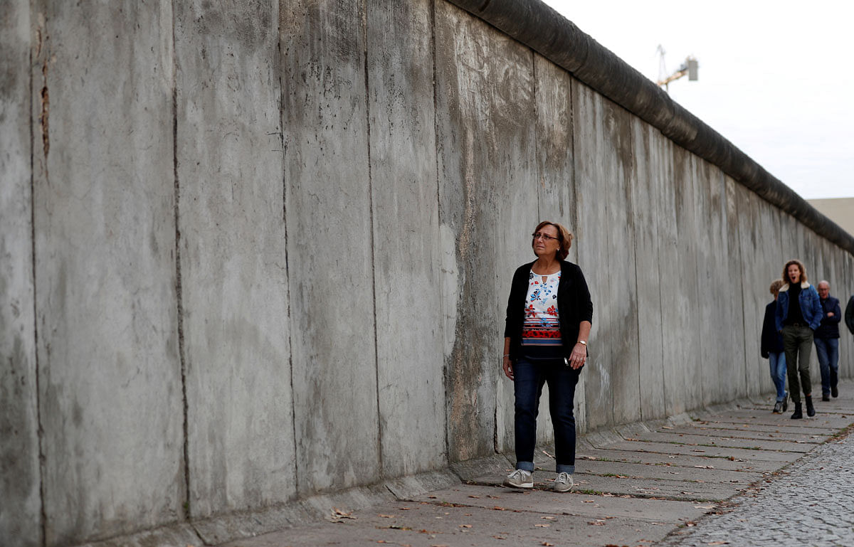 Angelika Bondick, a 63 year-old West Berlin sales assistent walks along the Berlin Wall memorial on Bernauer Strasse in Berlin. Photo: Reuters