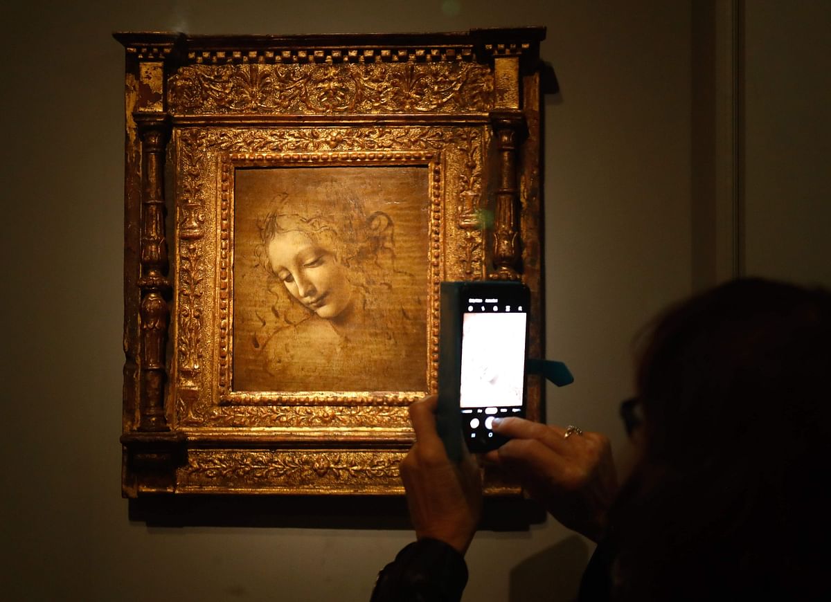 A person take a picture with mobile phone at an oil on wood painting by Leonardo da Vinci`s ` The Head of a Woman—also known as La Scapigliata `, during the opening of the exhibition ` Leonardo da Vinci `, on 22 October 2019 at the Louvre museum in Paris. Photo: AFP