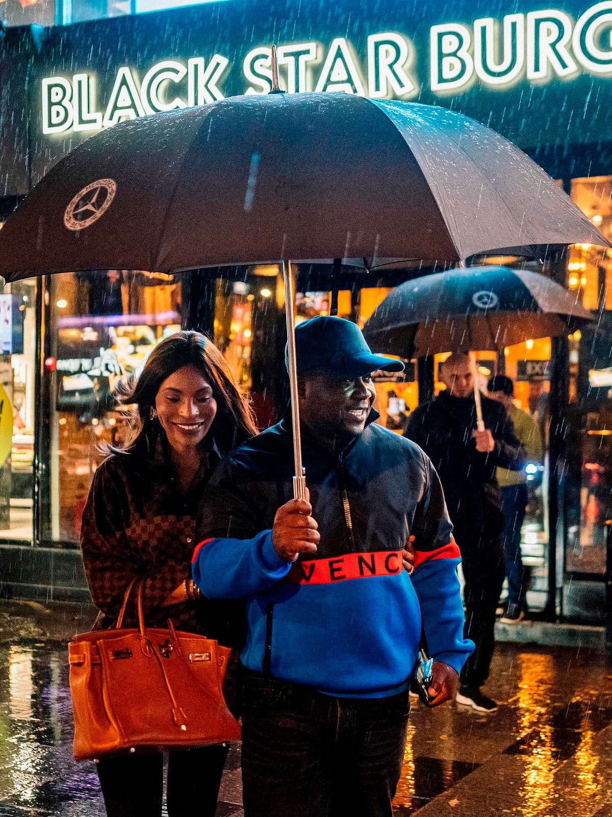 Cameroonian entrepreneur couple - Walter, 37, and Cindy, 32, Tchassem - walk outside an outlet of the couple`s Black Star burger chain on Moscow`s Novy Arbat after speaking with AFP on 21 October 2019. Photo: AFP
