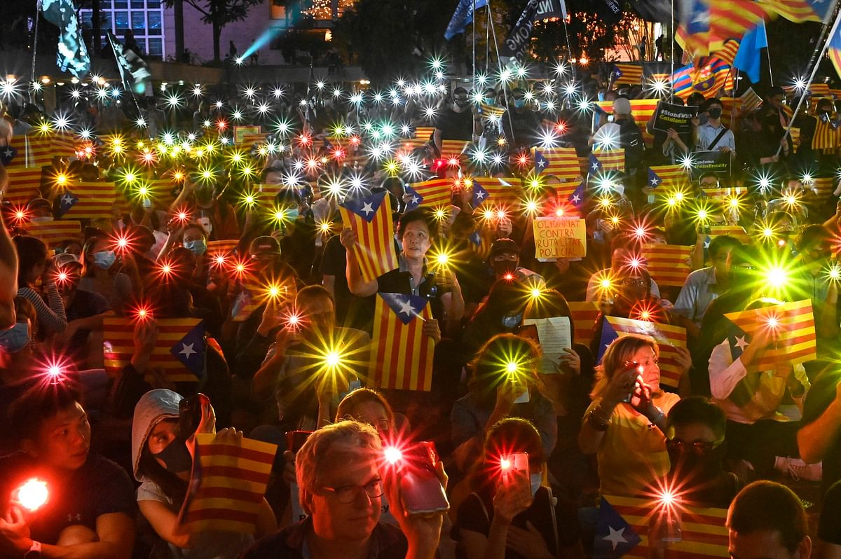 People hold Catalan pro-independence `Estelada` flags and light up their mobile phones during a Hong Kong-Catalonia solidarity assembly in Central district in Hong Kong on 24 October 2019. Photo: AFP