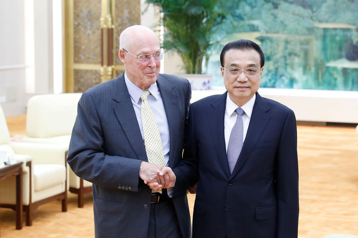 Chinese Premier Li Keqiang shakes hands with former US Treasury Secretary Henry Paulson before a meeting at the Great Hall of the People in Beijing, China on 23 October 2019. Reuters File Photo