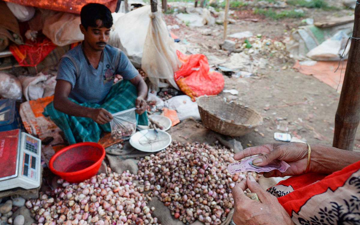 A vegetable vendor sells discarded and semi-rotten onions at a market of a low-income area in Dhaka on 27 October, 2019, as onion prices have shot past 1.4 USD per KG, forcing poor families to buy semi-rotten onions bulbs. Photo: AFP