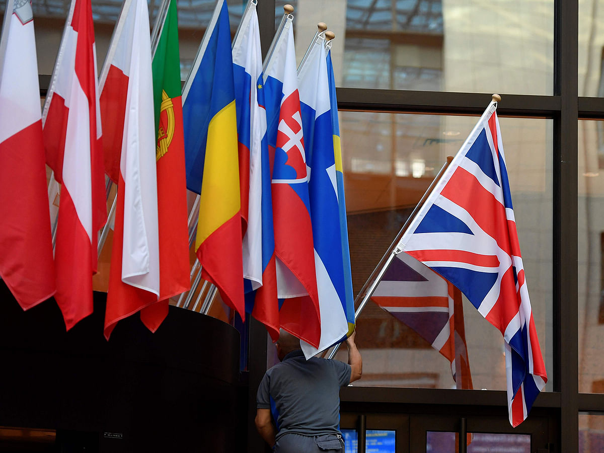 An employee hangs a Union Jack at the entrance of Consilium building at the EU Headquarters in Brussels on 28 October 2019. Photo: AFP