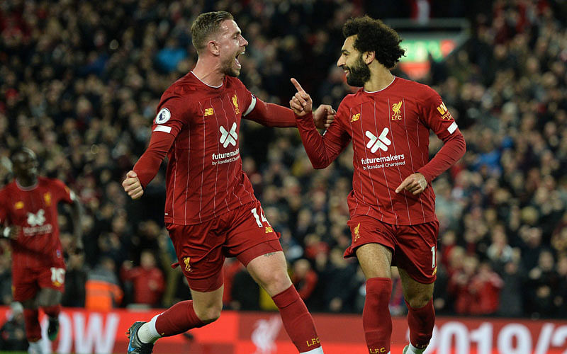 Liverpool’s Egyptian midfielder Mohamed Salah ® celebrates with Liverpool’s English midfielder Jordan Henderson after scoring a penalty during the English Premier League football match between Liverpool and Tottenham Hotspur at Anfield in Liverpool, north west England on 27 October 2019. Photo: AFP