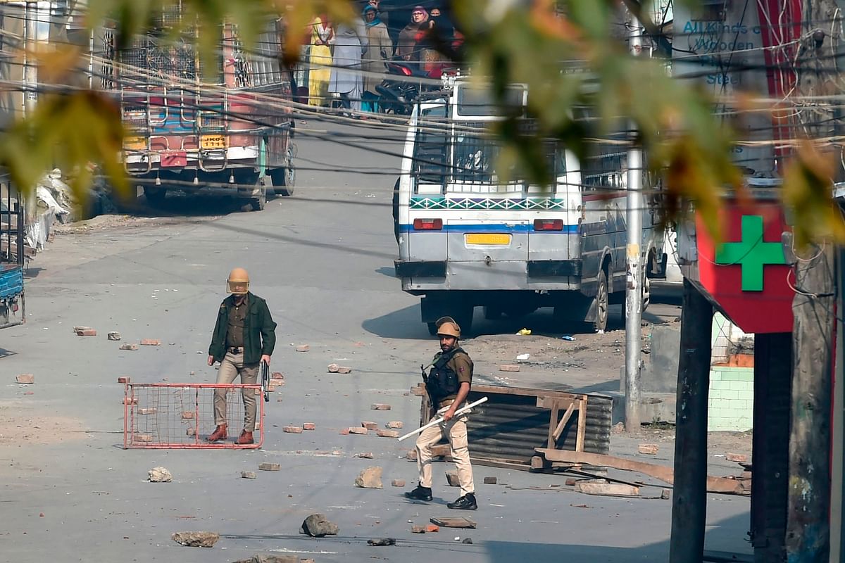 Indian government forces stand along a road scattered with stones during clashes with Kashmiri protestors, in Srinagar on 29 October, 2019. Photo: AFP