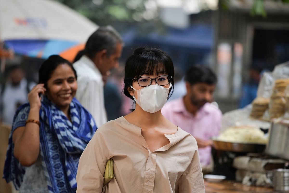 A woman wearing a protective face mask walks along a street under heavy smog conditions in New Delhi on 29 October, 2019. Photo: AFP