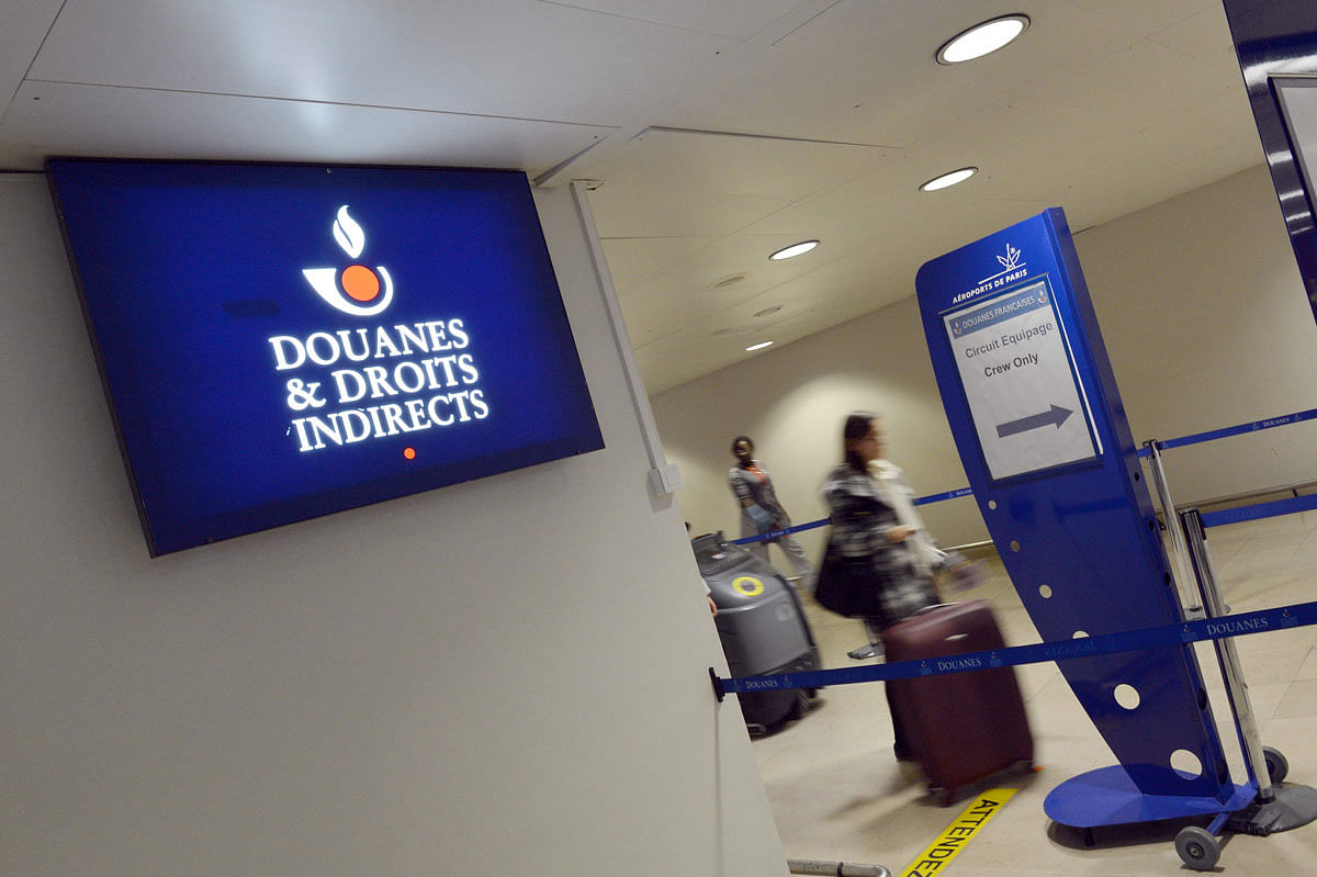 In this file photograph taken on 28 December 2012, shows passengers as they the logo of the French customs (douanes) at Orly airport, south of Paris. Every day they come, drug mules from French Guiana in South America, carrying cocaine in their luggage or their stomachs, playing a cat-and-mouse game with customs officials at Paris` Orly airport. Photo: AFP