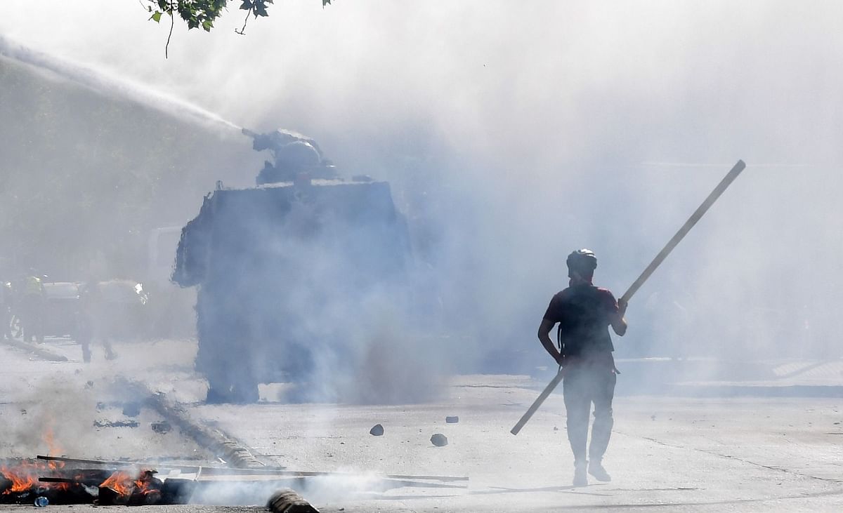 A demonstrator clashes with riot police during protests against the government economic policies, in the surroundings of La Moneda presidential palace in Santiago, on 29 October 2019. Photo: AFP