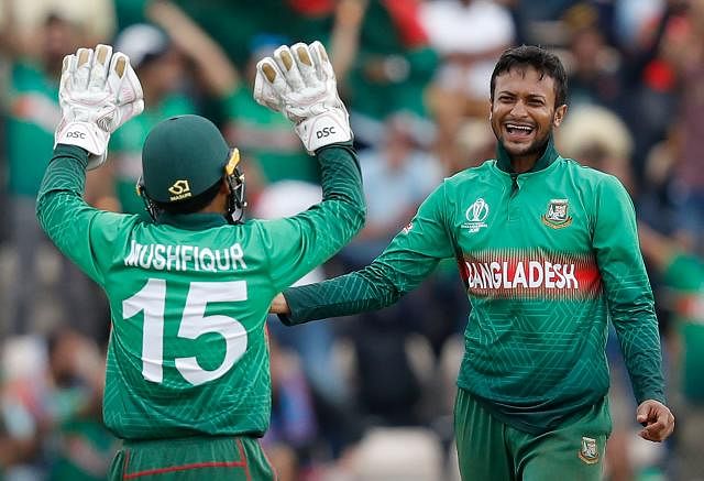 Shakib Al Hasan (R) celebrates with teammate Mushfiqur Rahim after the dismissal of Afghanistan’s Najibullah Zadran during their 2019 Cricket World Cup group stage match at the Rose Bowl in Southampton, southern England, on 24 June 2019. AFP File Photo