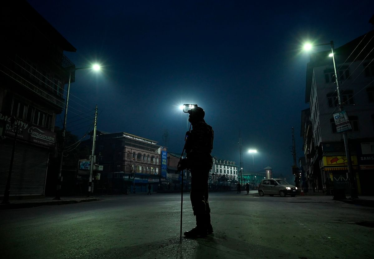 An Indian paramilitary trooper stands guard along a road during a lockdown in Srinagar on 30 October 2019. Photo: AFP