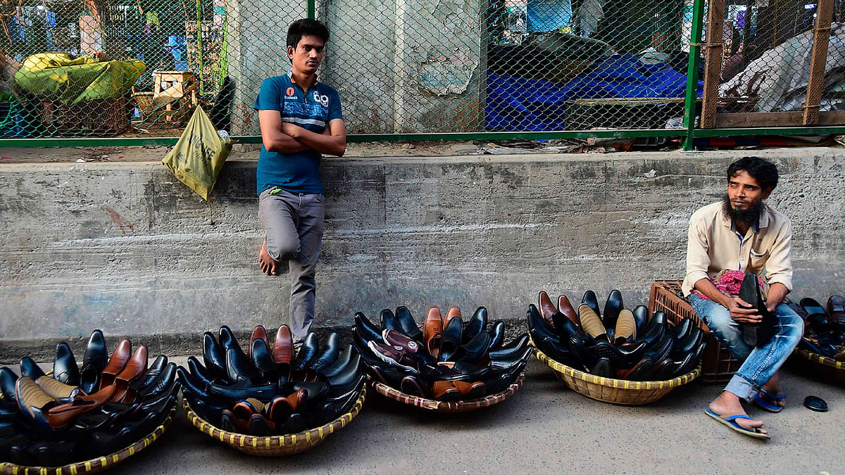 Bangladeshi street shoe vendors wait for customers in Dhaka on 30 October 2019. Photo: AFP