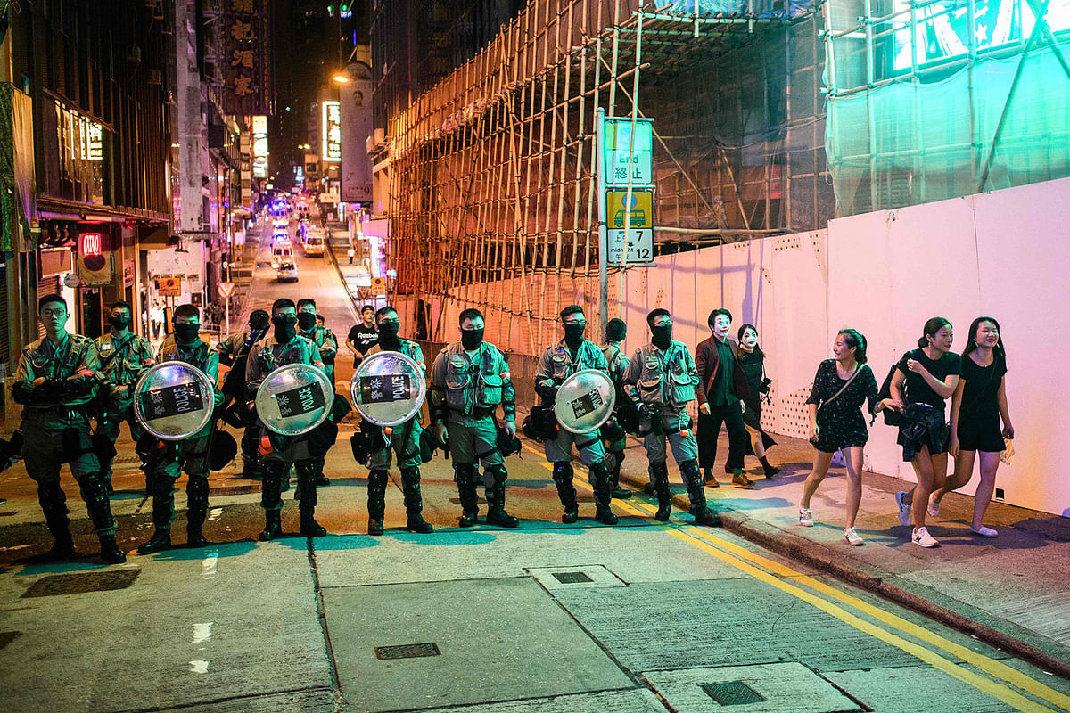 A group of revellers (R) walk past a line of riot police as they block entry to the Lan Kwai Fong area during Halloween in Hong Kong n 31 October 2019. Hong Kong democracy activists donned Halloween masks lampooning the city`s pro-Beijing leaders on 31 October 2019, defying an emergency law that bans face coverings and sparking renewed clashes with police. Photo: AFP