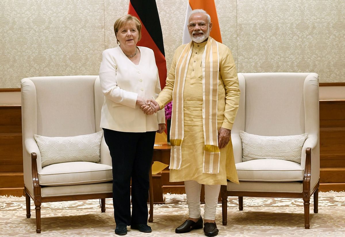 This handout photograph released by India`s Press Information Bureau (PIB) and taken on 1 November 2019 shows India`s Prime Minister Narendra Modi (R) shaking hands with German Chancellor Angela Merkel during a meeting at the Lok Kalyan Marg in New Delhi. Photo: AFP
