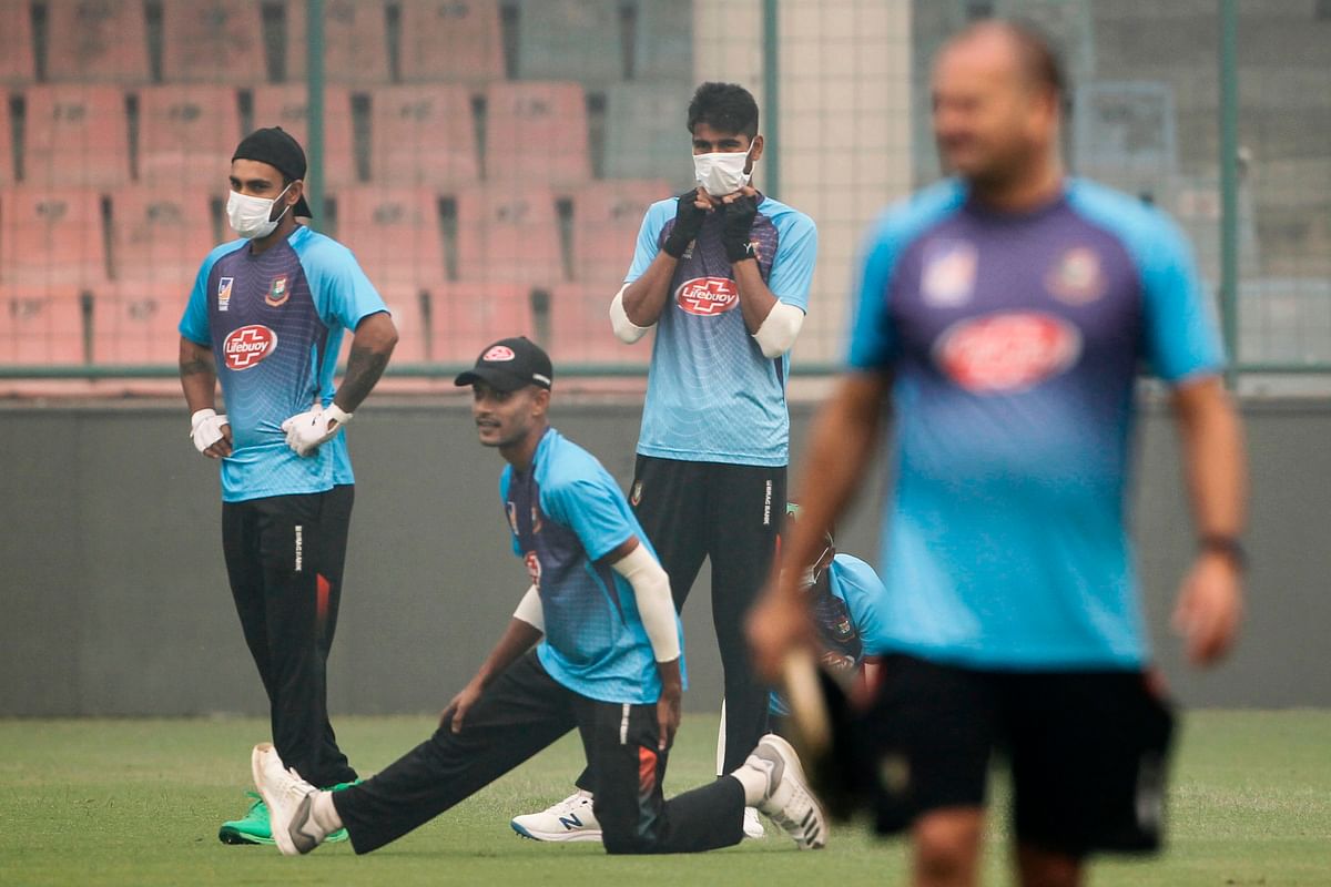 Bangladesh’s cricketers wearing face masks warm up during a practice session under heavy smog conditions at Arun Jaitley Cricket Stadium in New Delhi on 2 November 2019, ahead of the first T20 international cricket match of a three-match series between Bangladesh and India. Photo: AFP