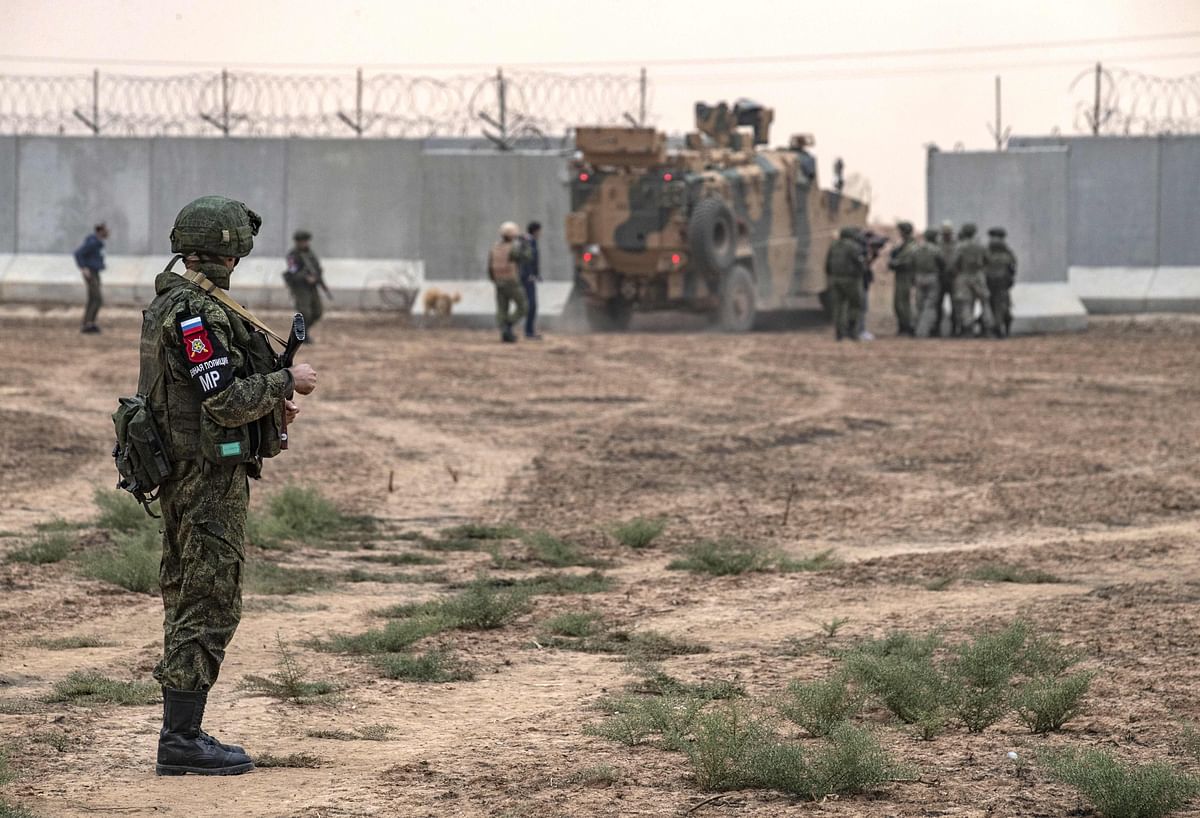 A Russian soldier watches as Turkish military vehicles cross the border to Turkey after patrolling with Russian forces, in the countryside of Darbasiyah town in Syria`s northeastern Hasakeh province on 1 November 2019. Photo: AFP