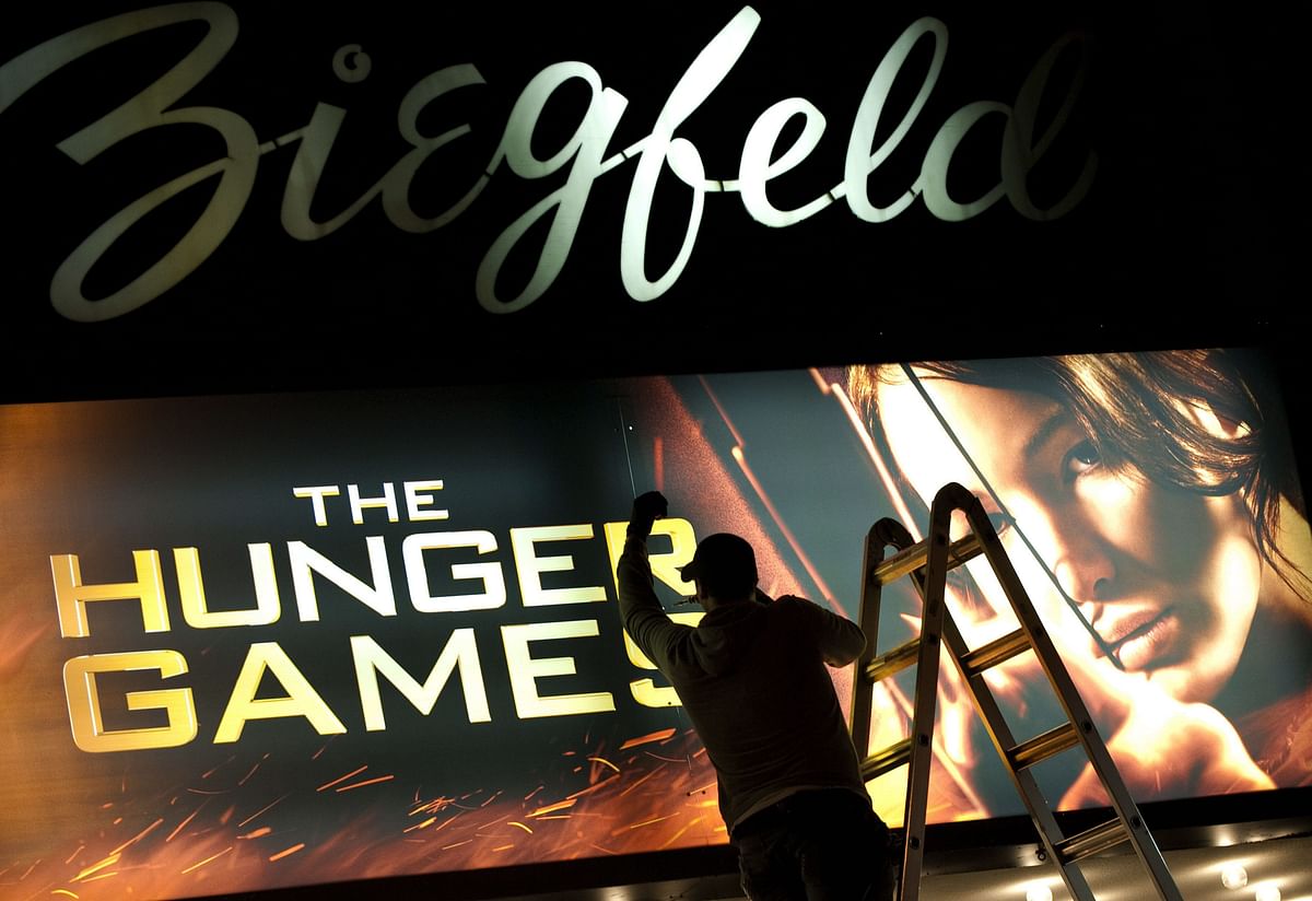 In this file photo taken on 22 March 2012 a worker swaps out the billboard marking the opening of `The Hunger Games` on 22 March 2012 at the Ziegfeld Theatre in New York. Photo: AFP