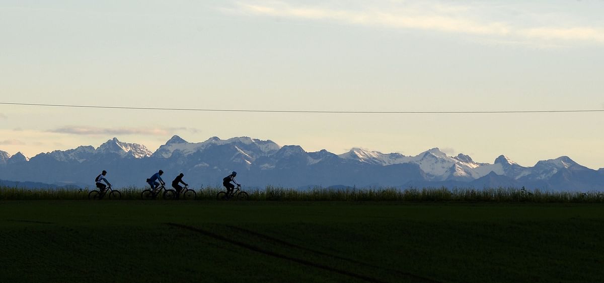 Cyclist`s drive in front of the Alp mountains during a warm autumn day with temperatures by 15 degrees near the small Bavarian village of Alling, southern Germany, on 2 November 2019. Photo: AFP