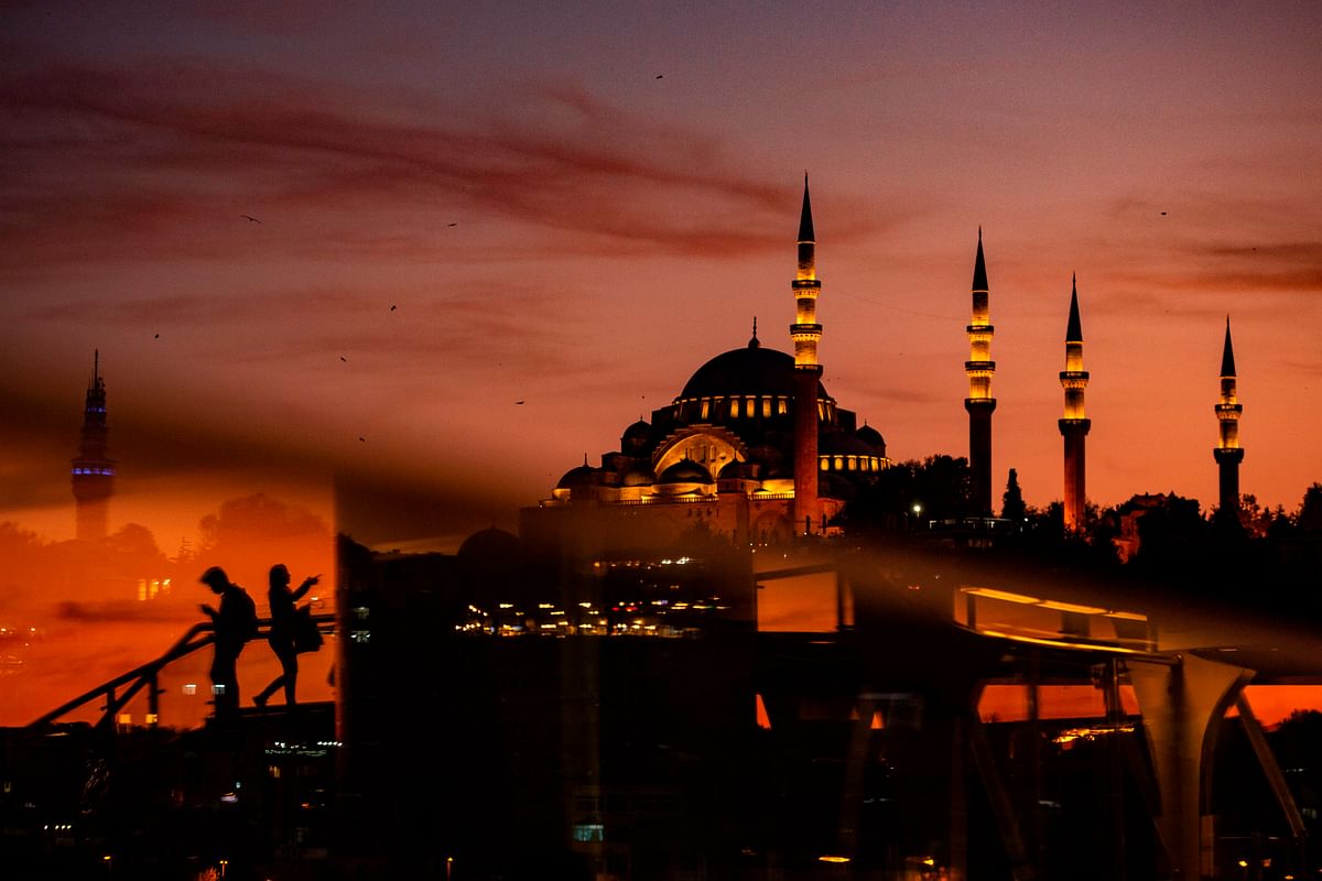 People cross the Halic bridge over the golden horn as Suleymaniye mosque is seen in the background during sunset over the historical Eminonu district on 2 November 2019 in Istanbul. Photo: AFP