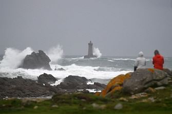People look at waves breaking over the `Phare du four` (lighthouse) off the western city of Porspoder on 2 November 2019 a few hours before the storm Amelie. Photo: AFP