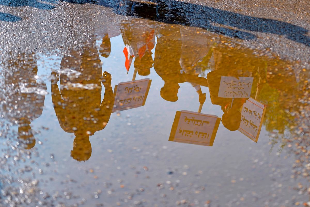 Iraqi protesters are reflected on a puddle during ongoing anti-government demonstrations in the southern city of Diwaniyah on 3 November 2019. Photo: AFP